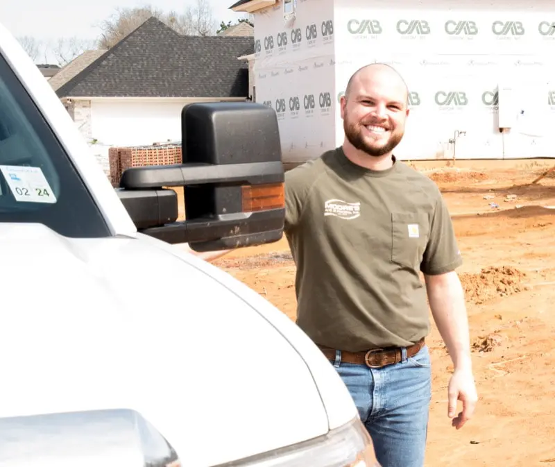 Jaden standing by Moore's A/C & Heating truck